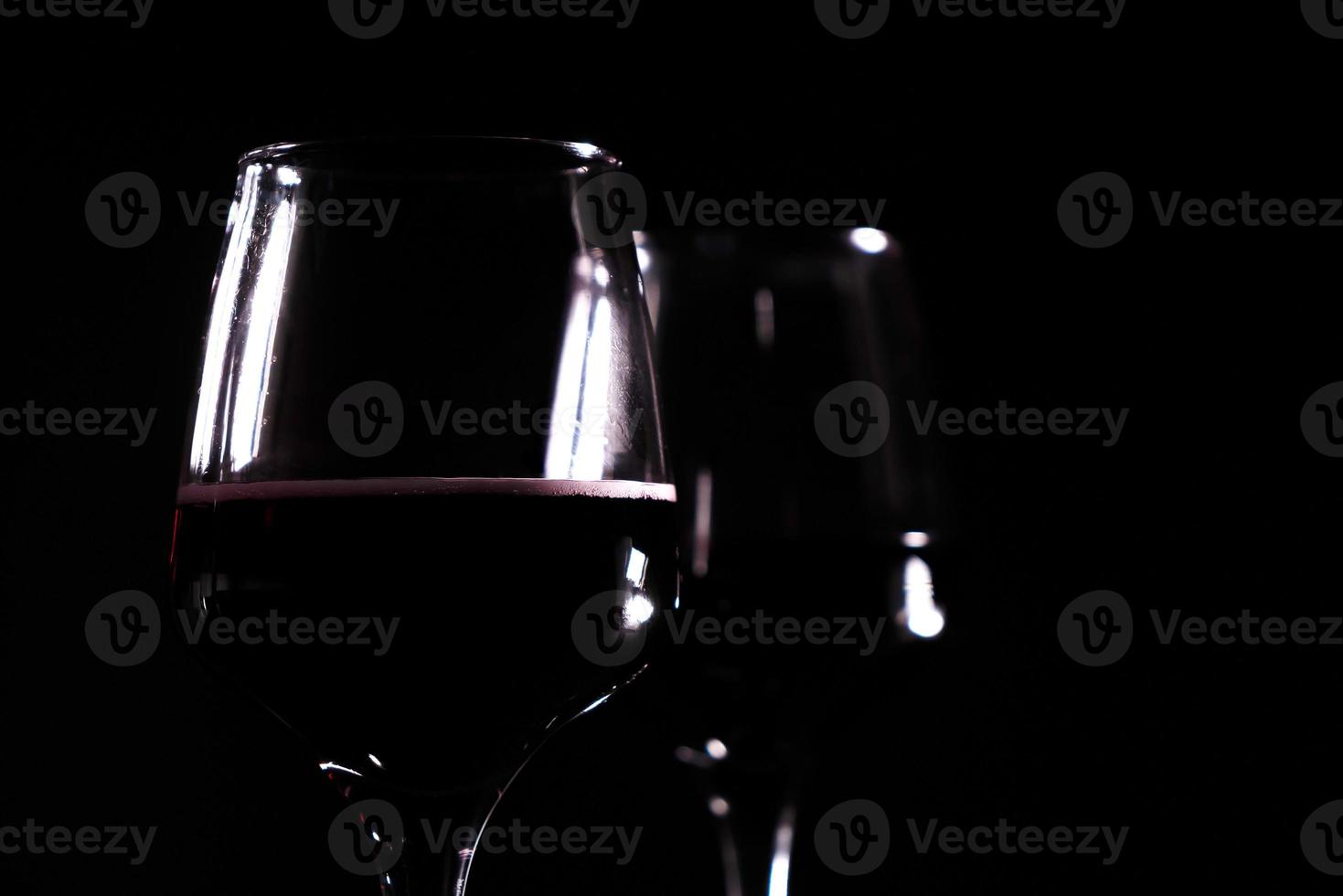 red wine in glass on the black background photo