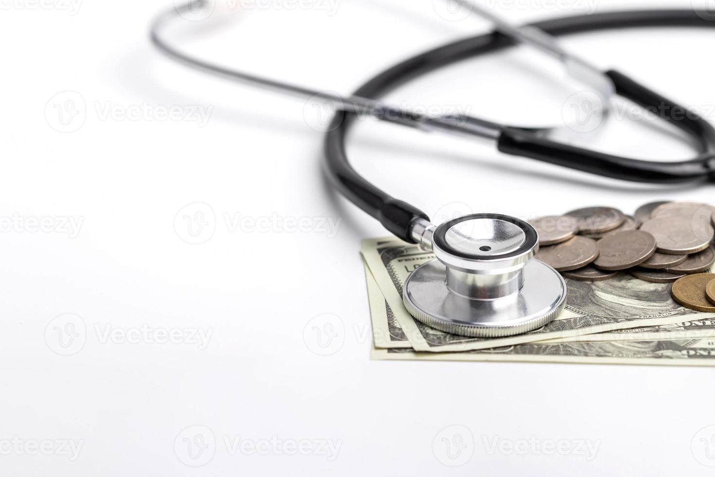 a stethoscope placed on banknotes with coins. photo