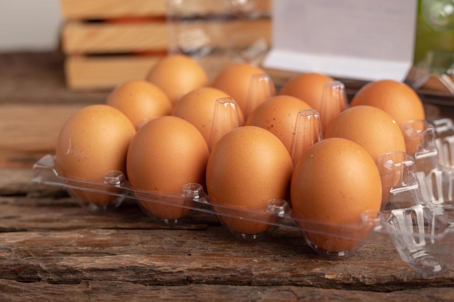 eggs of chicken in a plastic box placed on a wooden table photo