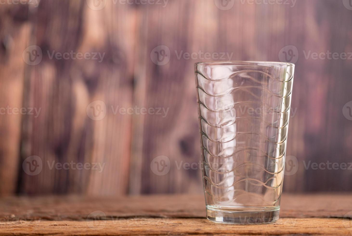 vaso de agua transparente vacío en la mesa de madera foto