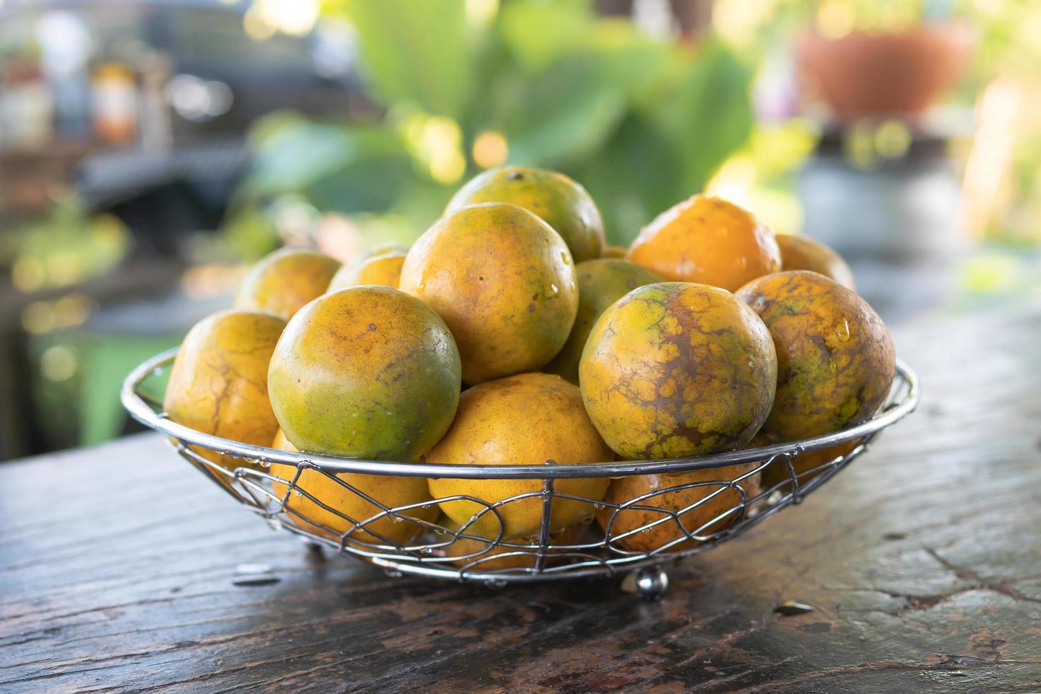 Tangerine in a silver metal basket on the table photo