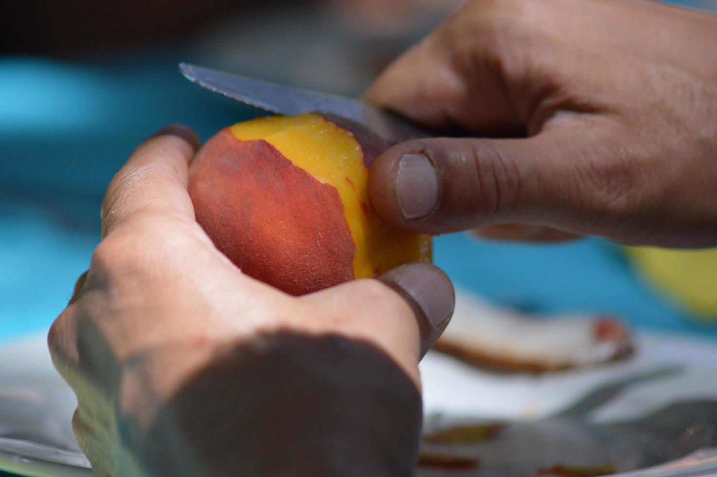 Someone peels a nectarine photo