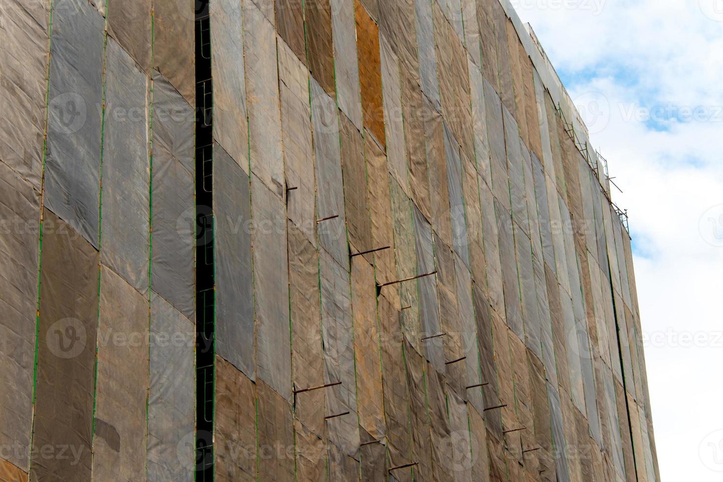 Several large canvases stretch together, Covered building under construction photo