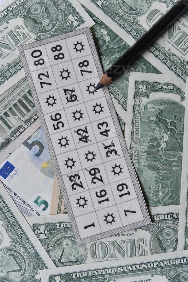Dollar bills and lottery tickets with a pencil photo