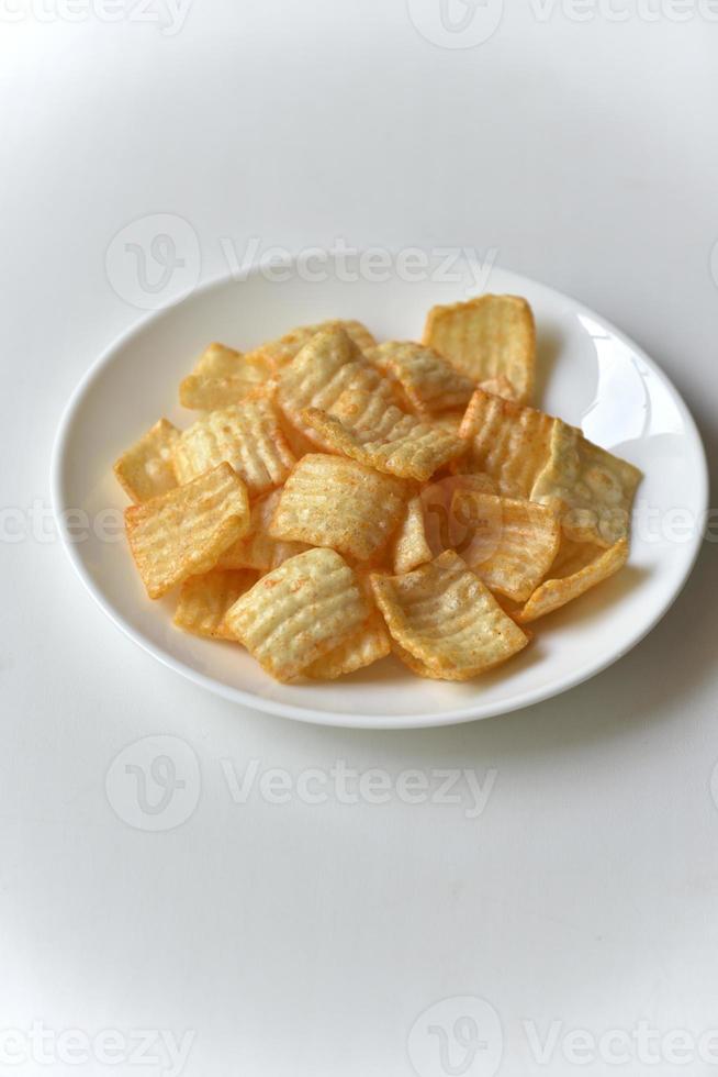 Delicious potato chips with pepper on a white plate photo