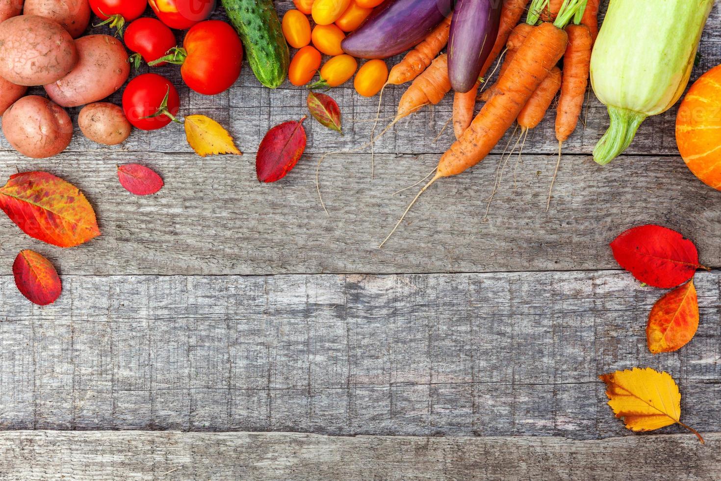 Surtido de diferentes verduras orgánicas frescas sobre fondo de madera de estilo rural. concepto de dieta vegetariana vegana de alimentos saludables. El jardín local produce alimentos limpios. espacio de copia plano de la vista superior del marco. foto