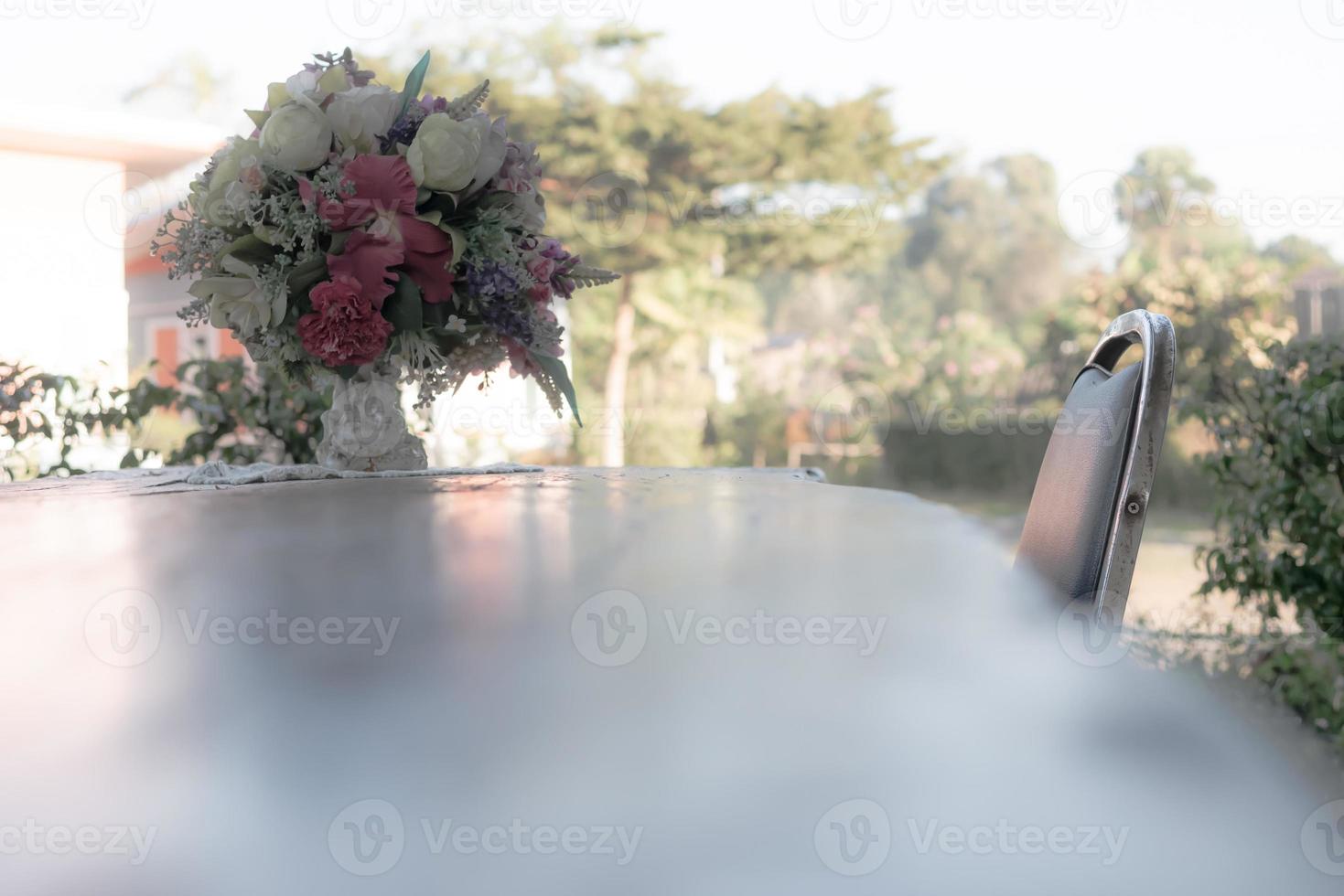 Chair and tables with vases placed flowers on the table in the front garden photo