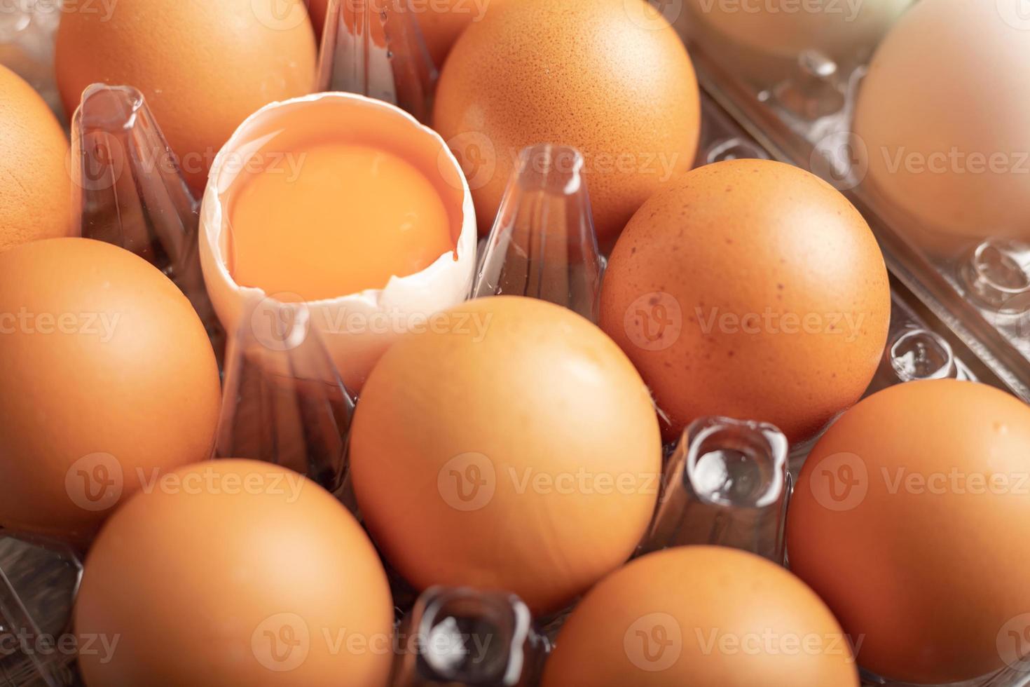 broken eggs of duck in plastic box on the wooden table photo