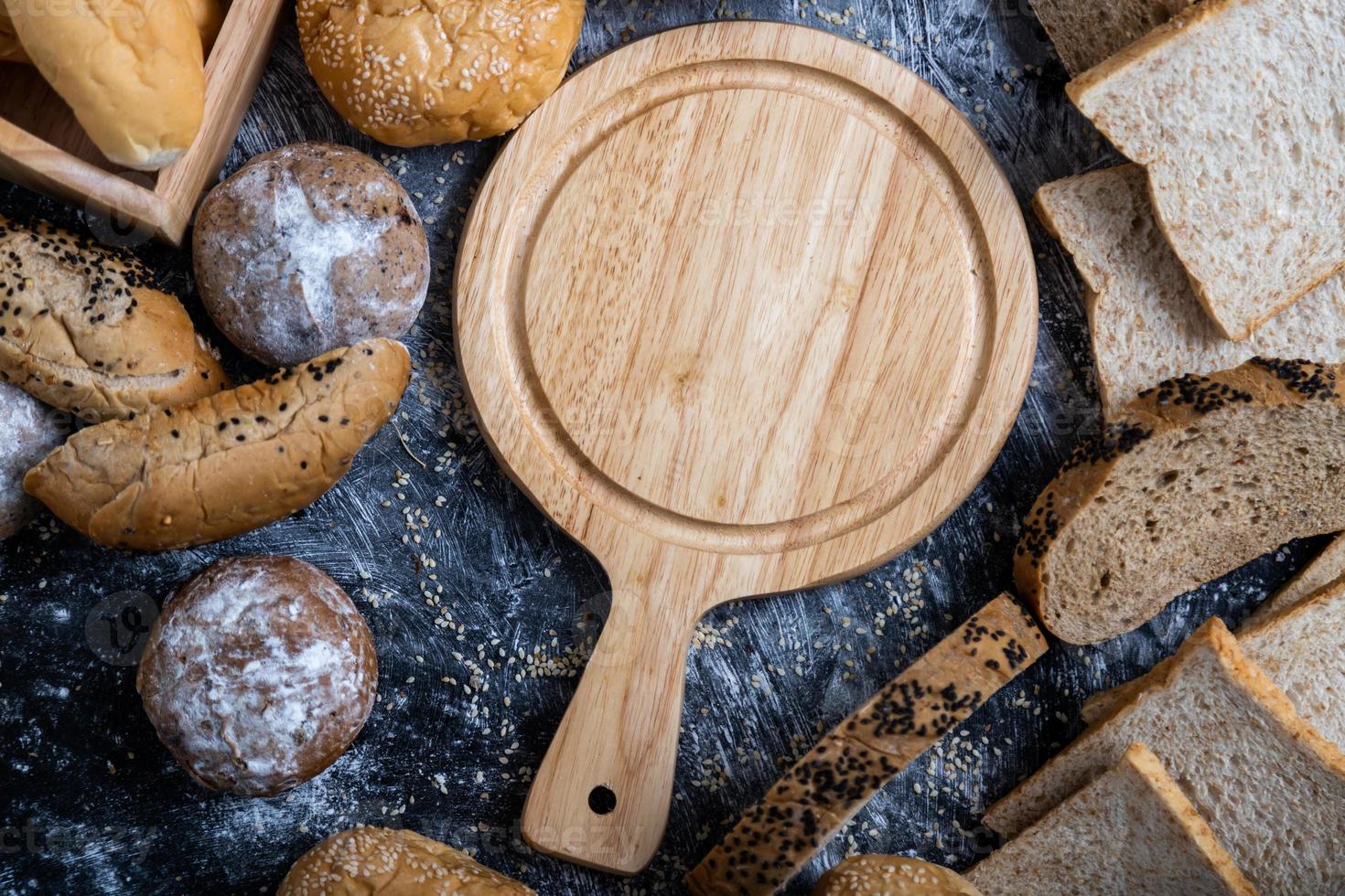 An empty wooden cutting board placed in the middle of the table photo