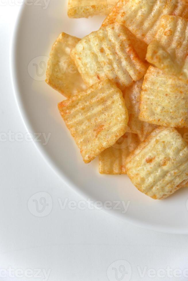 Delicious potato chips with pepper on a white plate photo