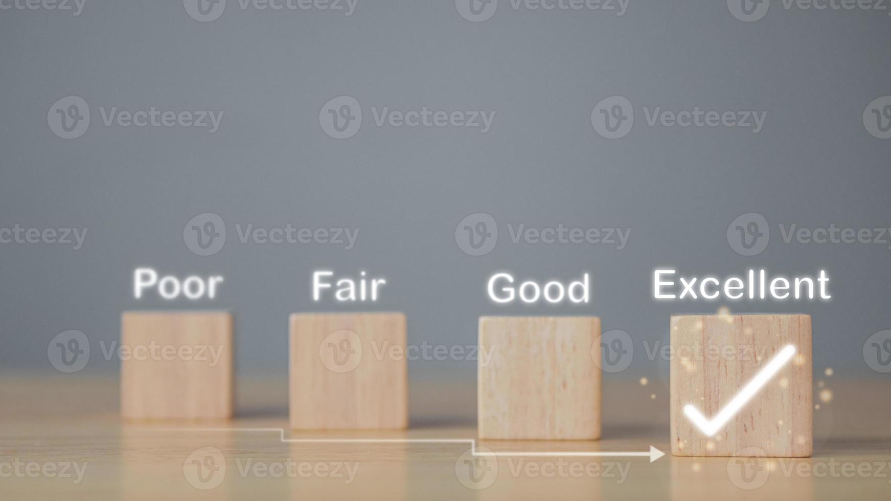 Evaluation and satisfaction concept. On wood blocks, a correct mark shows an excellent job and best service for customer. Copy space on grey background. photo