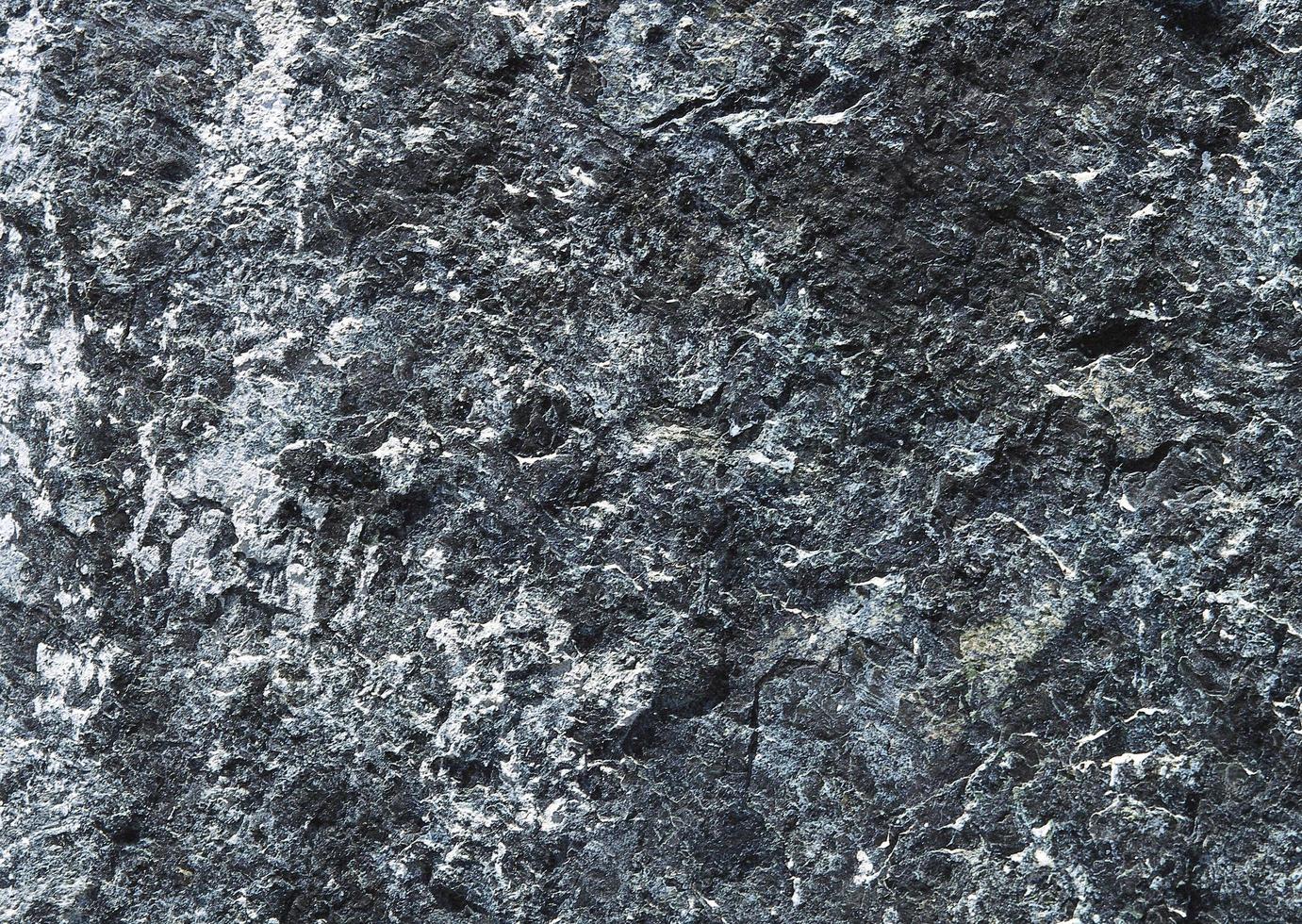 superficie de pared de roca de granito oscuro, textura de fondo abstracto. foto