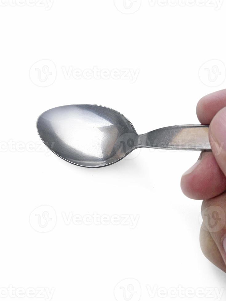 Spoon in hand on white background photo