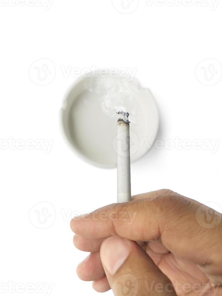 A man's hand flicks the ashes of the burning cigarette in the ashtray. Smoking is harmful to health photo