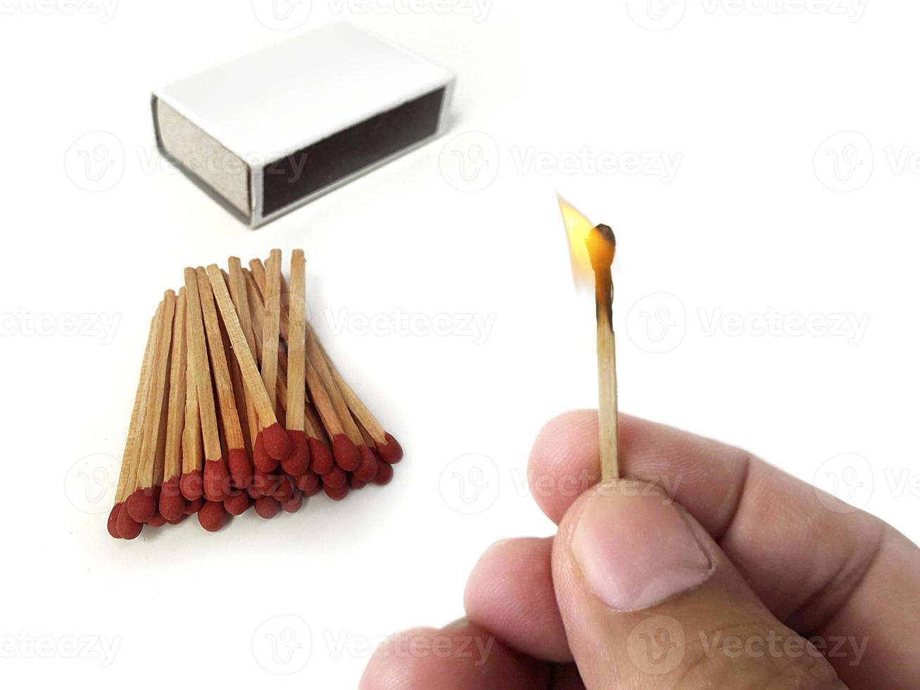 Male hands hold a match with a flame and Box of matches. isolated on a white background photo