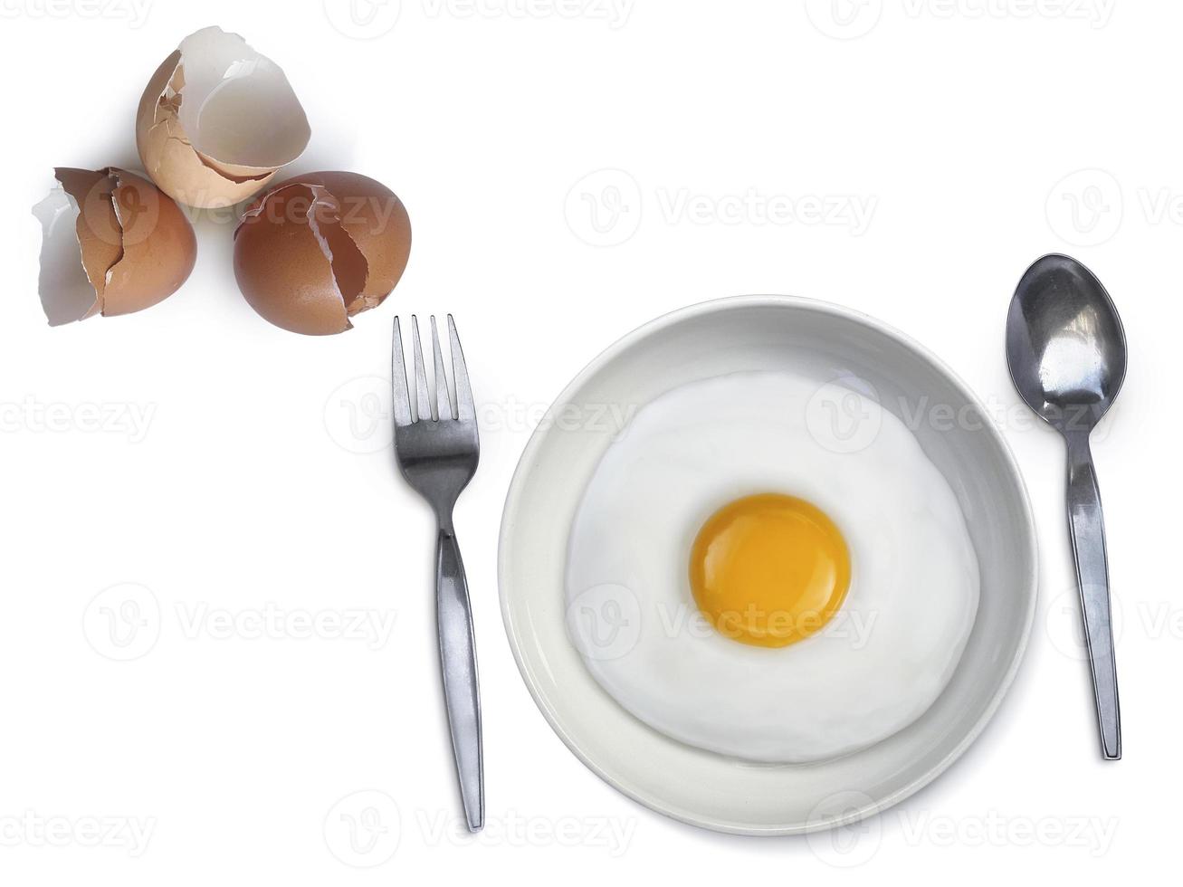 spoon fork fried egg on plate on a white background photo