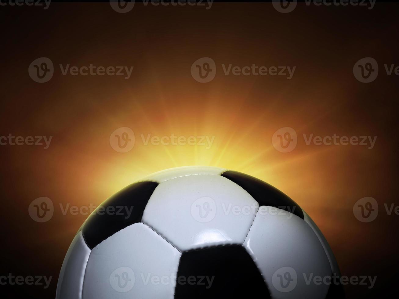 soccer ball ball. on black background with smoke, yellow orange red white colored back lights photo