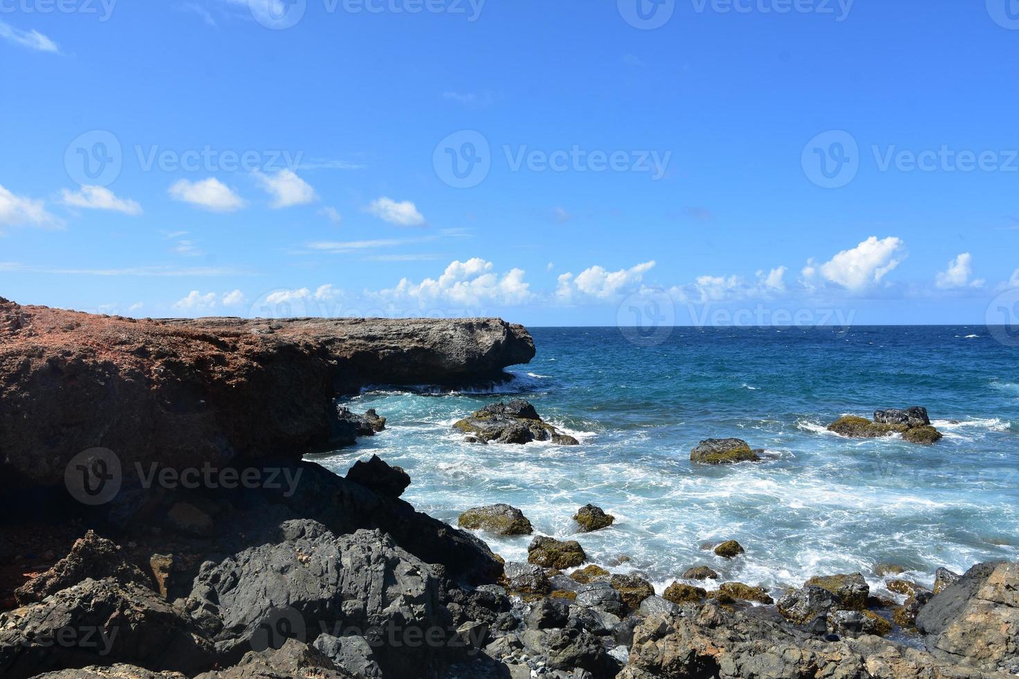 Black Lava Rock with Waves Coming Ashore in Aruba photo