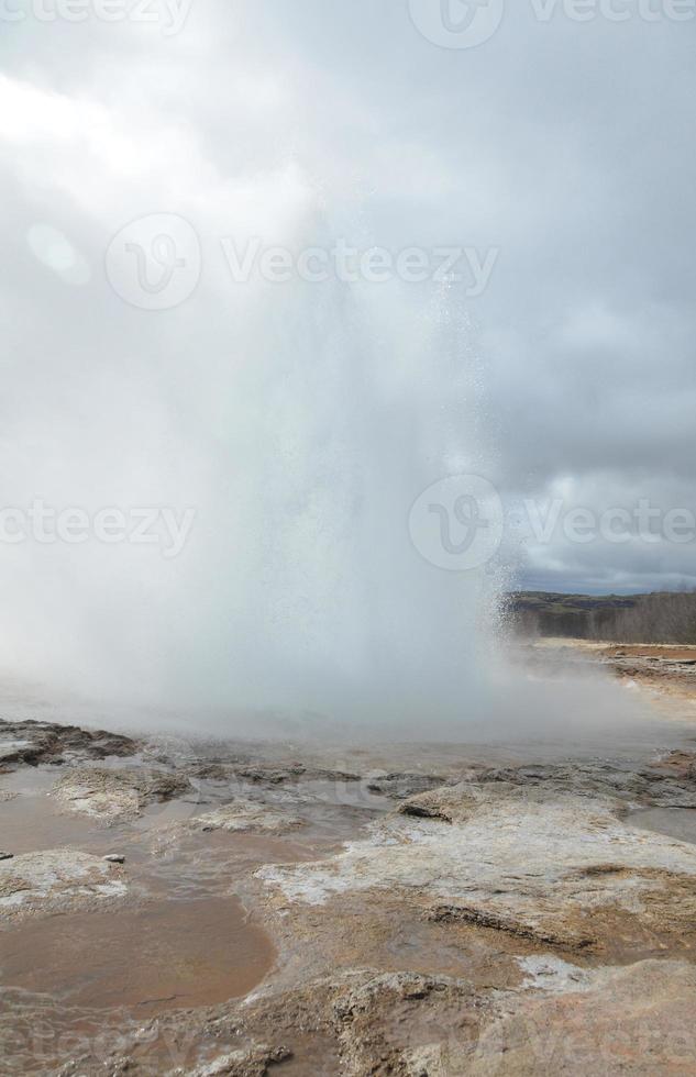 Erupting geyser in Iceland on a cloudy day photo