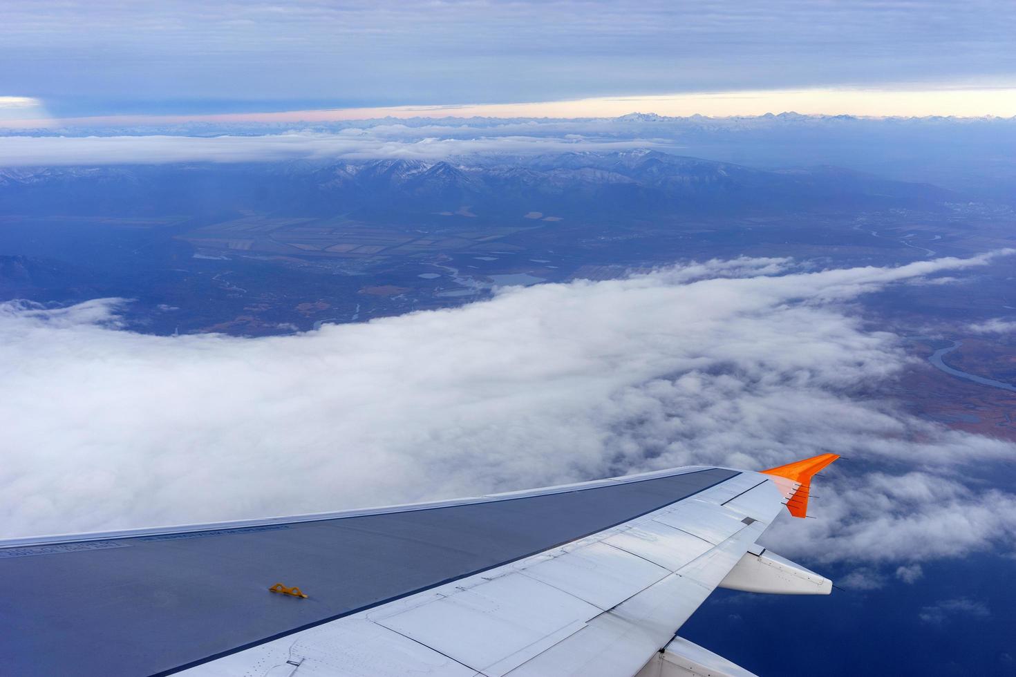 el ala del avión contra el fondo del paisaje con nubes foto