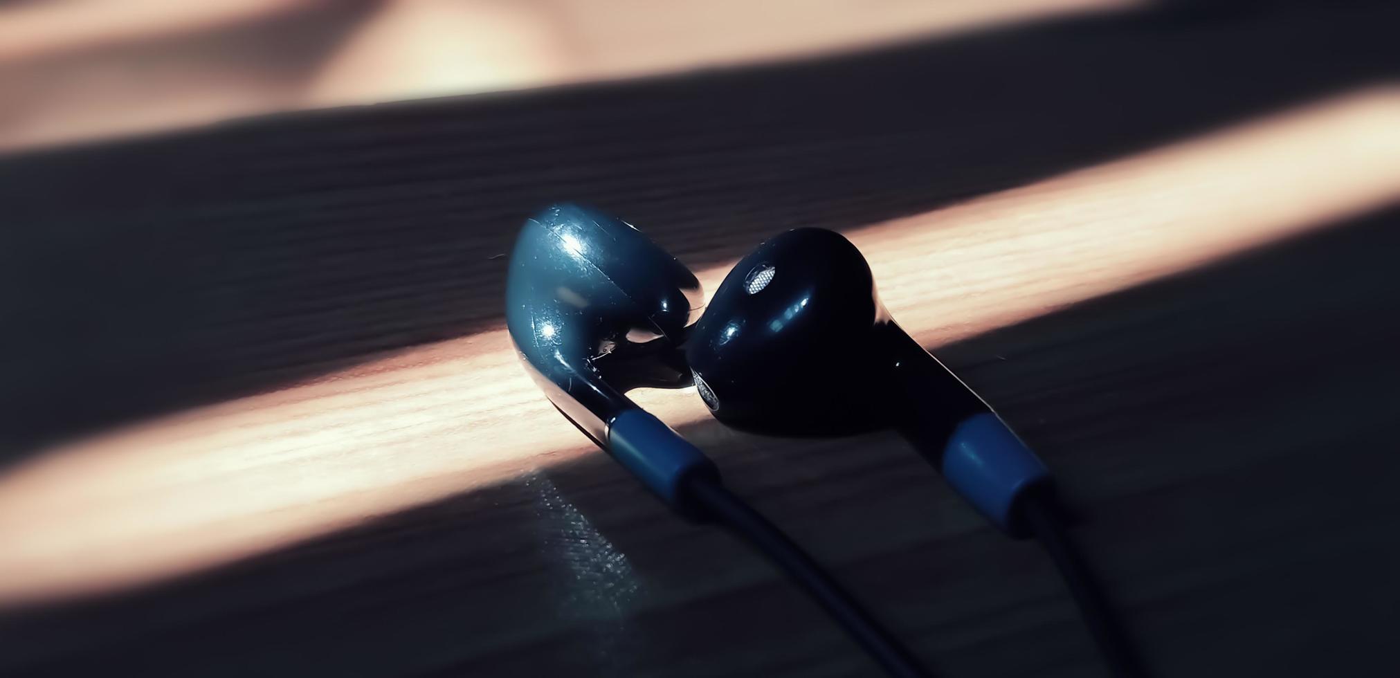 Photography earphones with shining light. Earphones are black. Photography earphone with blur effect photo