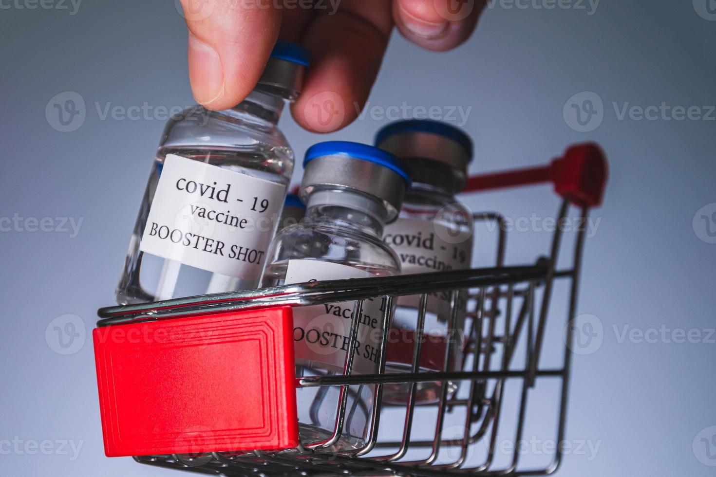 COVID-19 booster vaccine vials in shopping cart. Medicine and health care concept photo