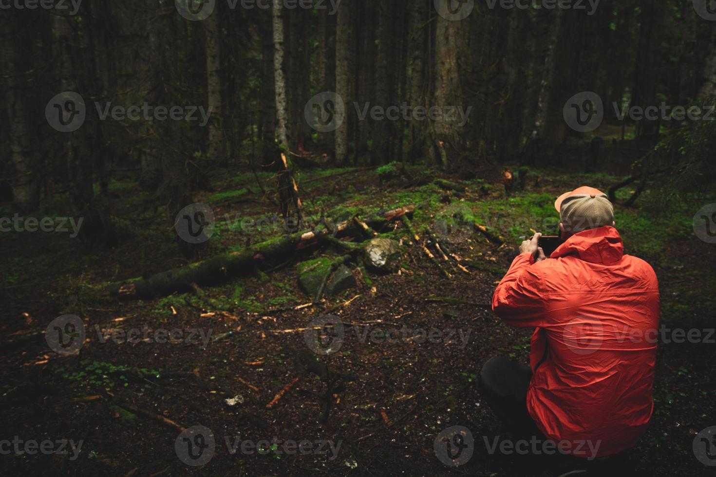 una persona toma una foto móvil con un smartphone de un bosque oscuro y cambiante en la región de racha, georgia, desde un ángulo bajo al aire libre