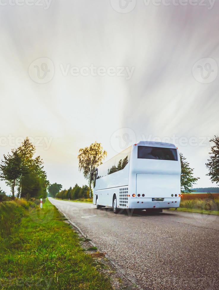 White city bus on the road in scenic countryside of Poland. Cloudy day. Excursions in eastern Europe.Dramatic sky. photo