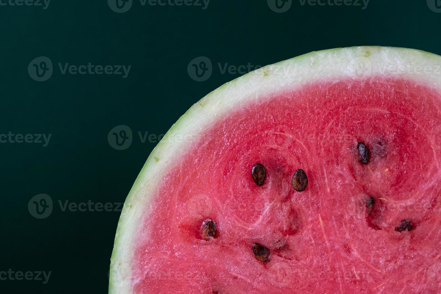 A half of fresh watermelon on dark background. Close-up macro photo. Fresh fruits texture. High quality photo