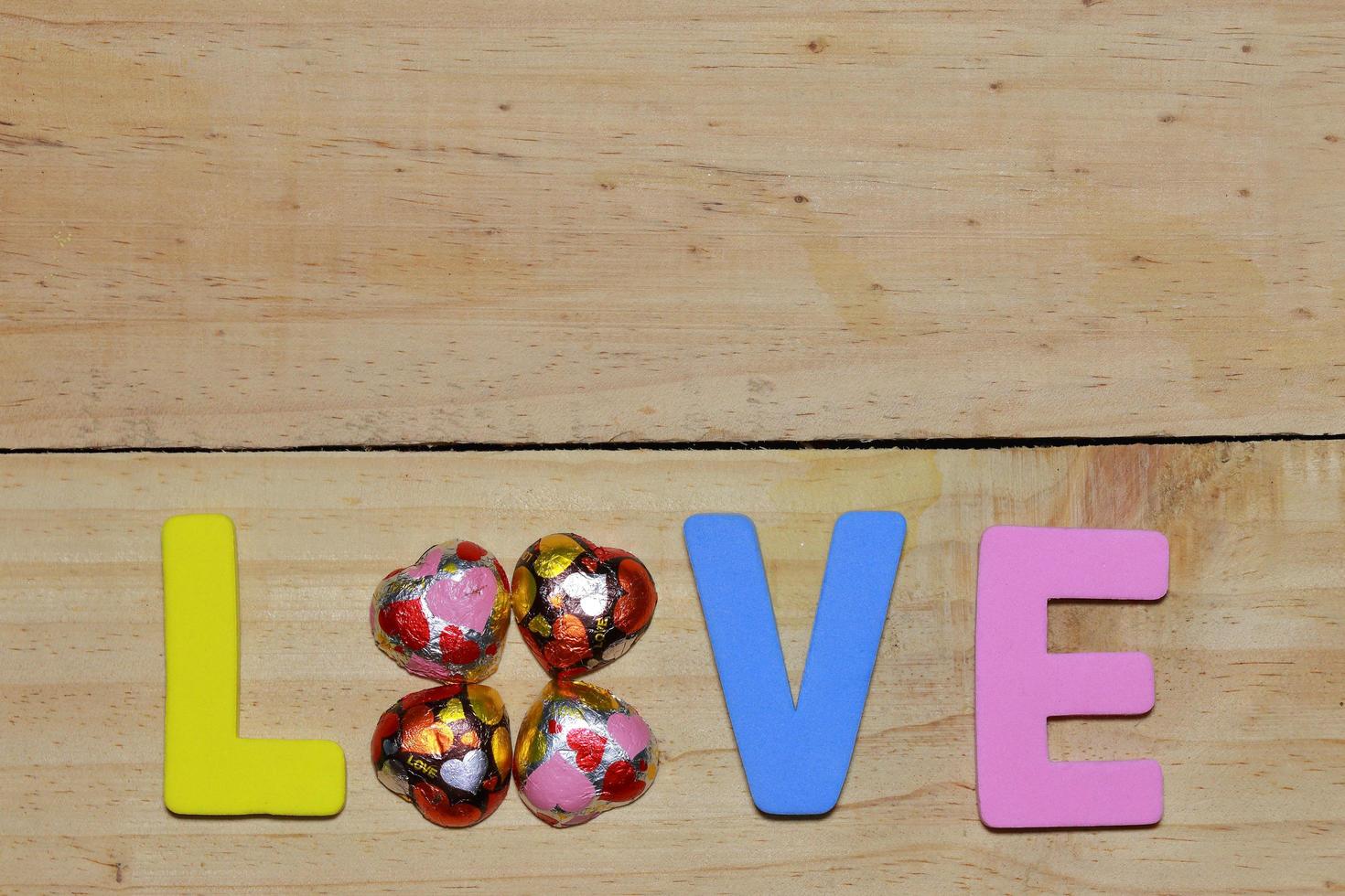 cartas de amor y corazón de chocolate en el suelo de madera. fondo del día de san valentín con corazones. concepto de San Valentín. espacio para texto. foto