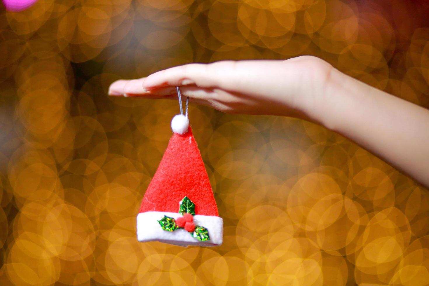 Merry Christmas and Happy New Year. Gift Christmas in woman's hands with glowing hearts bokeh. photo