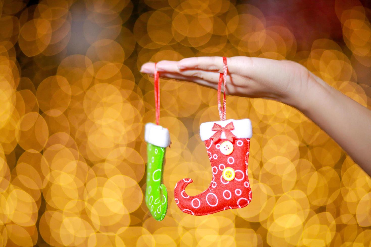 Merry Christmas and Happy New Year. Gift Christmas in woman's hands with glowing hearts bokeh. photo