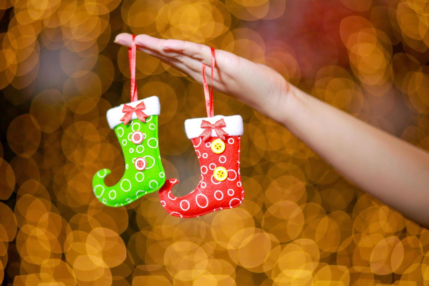 Merry Christmas and Happy New Year. Gift Christmas in woman's hands with glowing hearts bokeh. photo