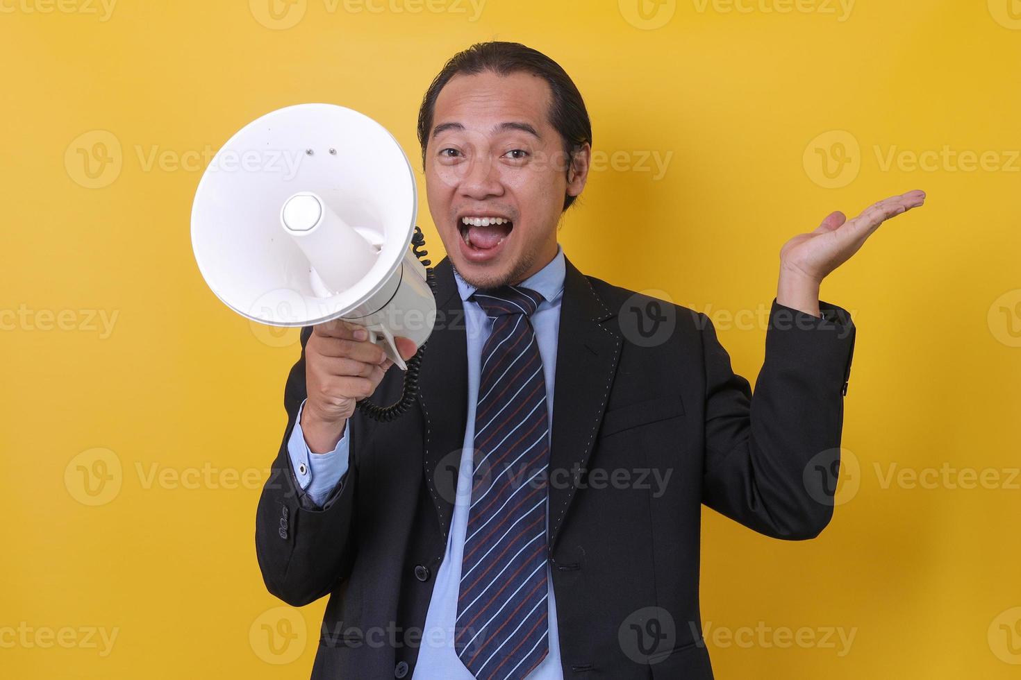 hombre de negocios asiático usando megáfono durante la presentación, retrato de primer plano aislado en fondo amarillo. foto