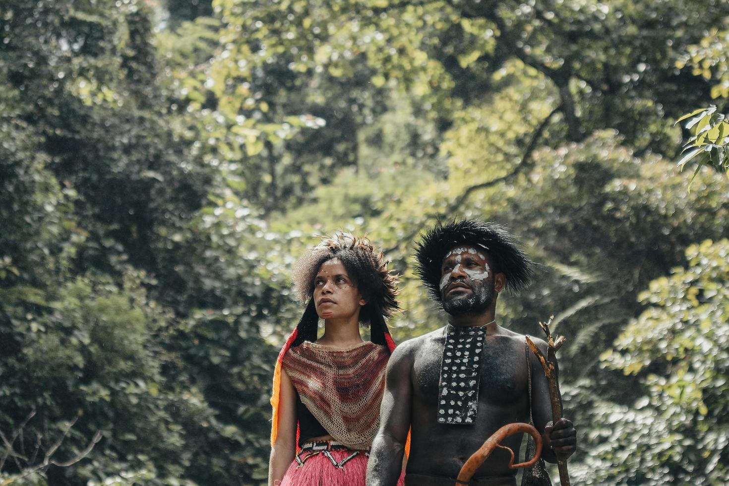 wamena, papúa, indonesia, 01 de junio de 2022 padre e hija de la tribu dani vestidos con ropa tradicional de pie juntos, contra el fondo del bosque verde. familia papúa. foto