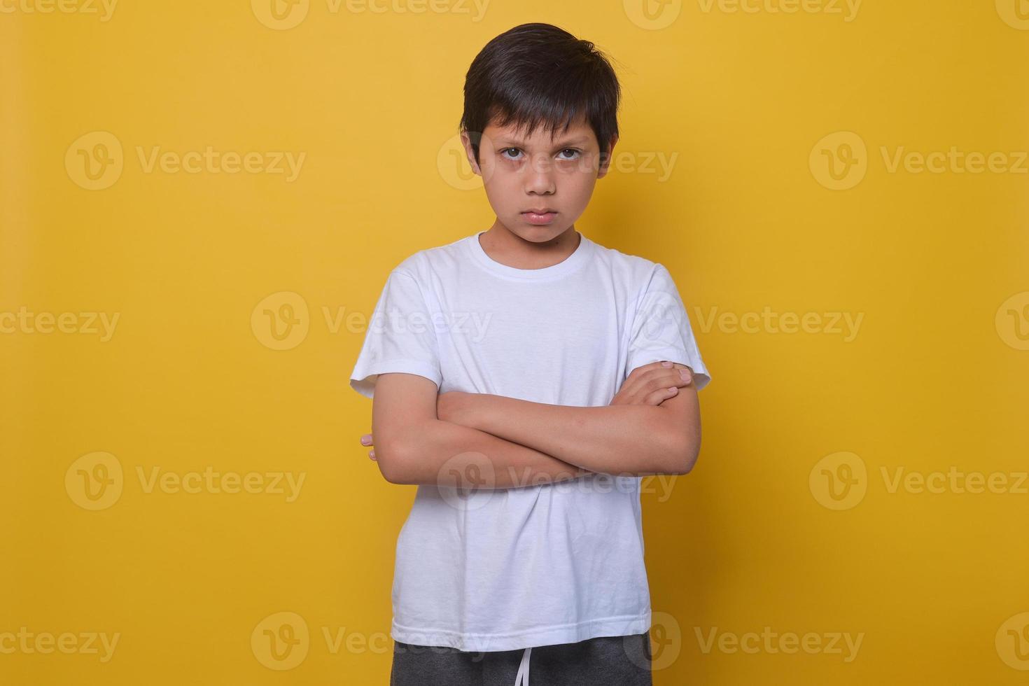 Asian boy in a casual style feeling annoyed and showing sad expression on yellow background. photo
