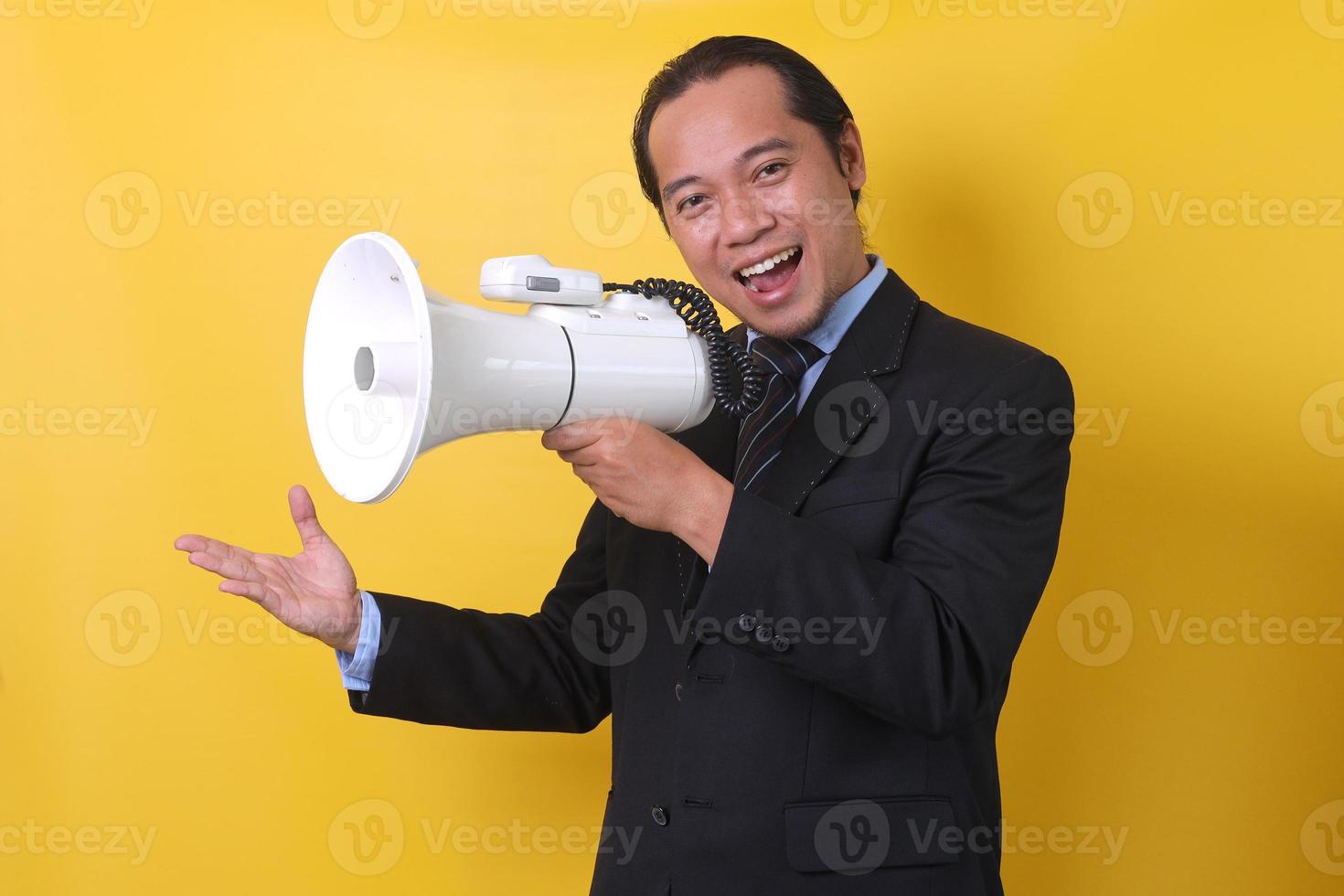 Asian businessman using megaphone closeup portrait isolated on yellow background. photo