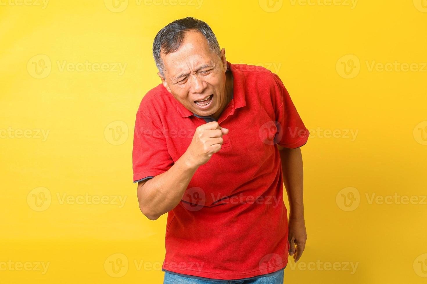 Asian senior man coughing isolated on yellow background. photo
