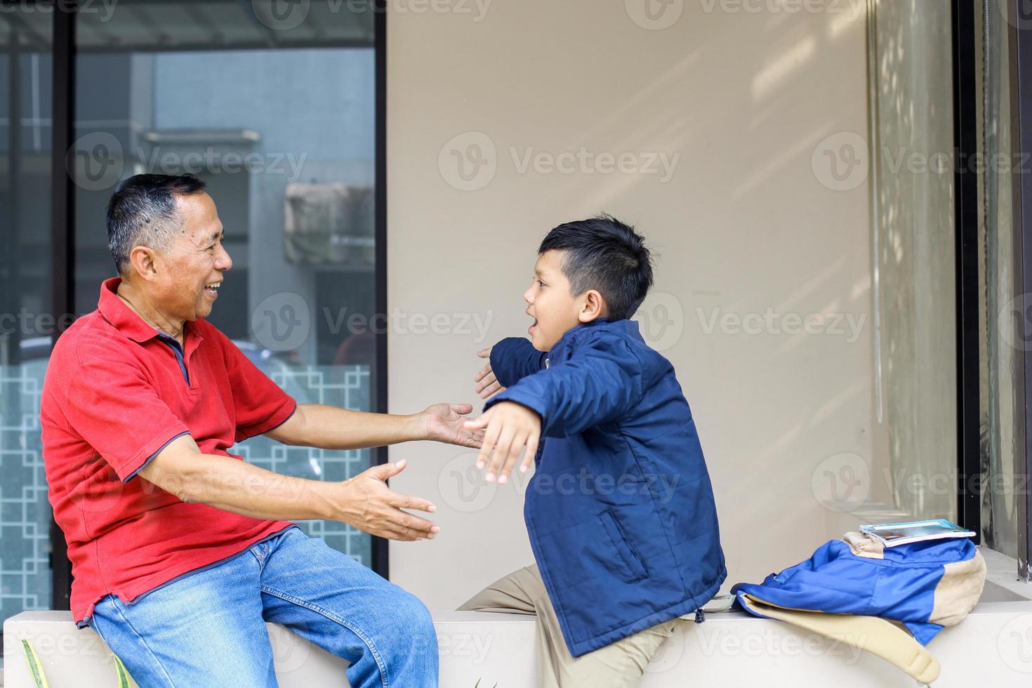 Grandfather playing with his grandson after school and they want to hug each other. Parenting and family activity concept. photo