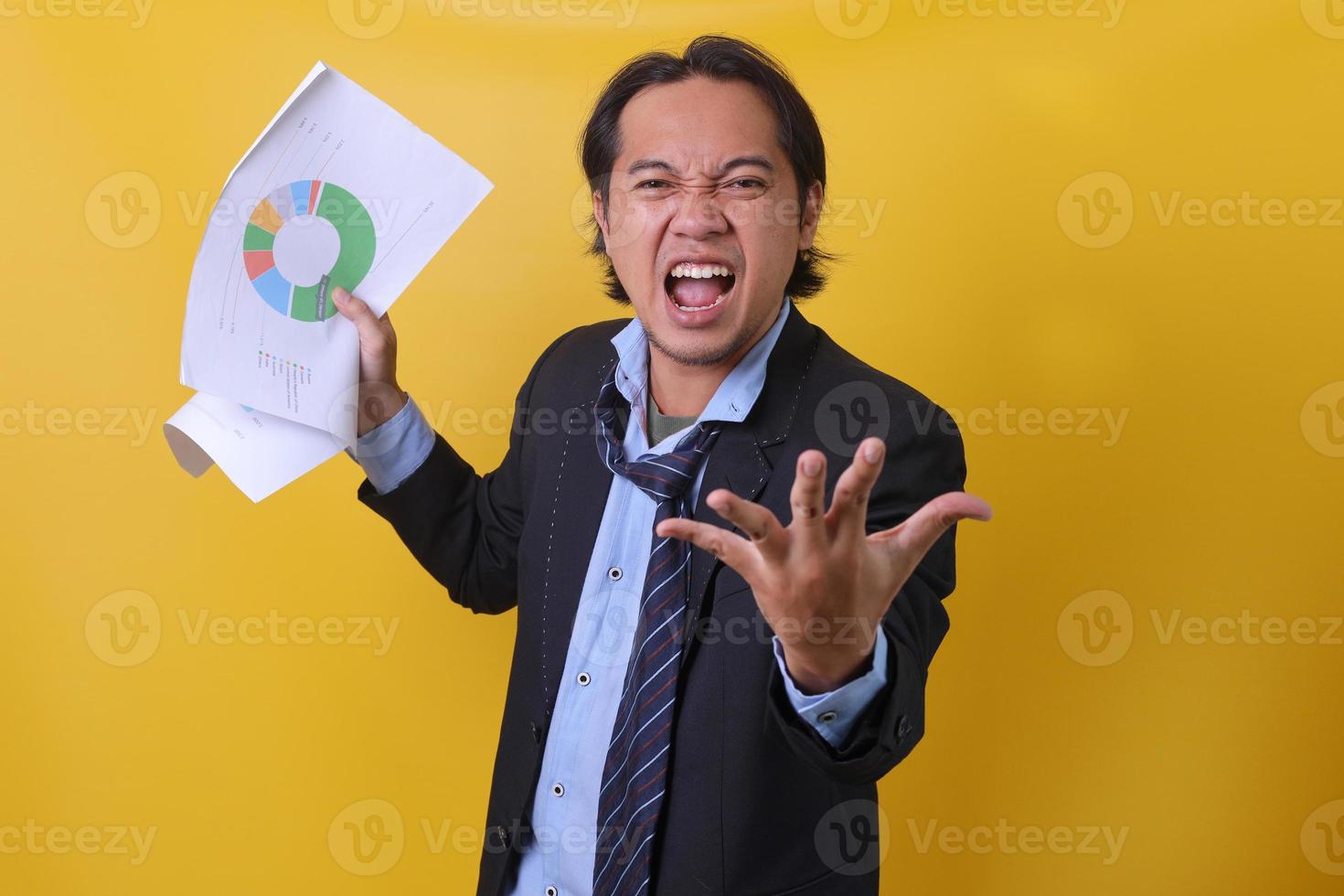 Angry boss screaming and showing a growth graph of bad report isolated on yellow background photo