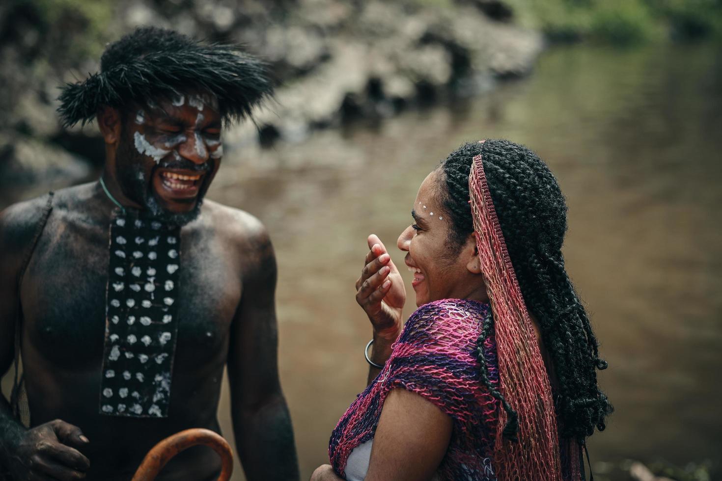 Wamena, Papua, INDONESIA, June 01, 2022 Papuans couple of Dani tribe are laughing against nature background. photo