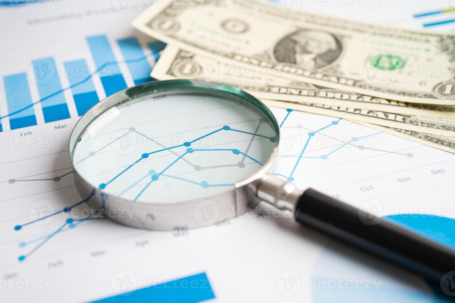 Magnifying glass with US dollar banknotes on charts graphs paper. Financial development, Banking Account, Statistics, Investment Analytic research data economy. photo