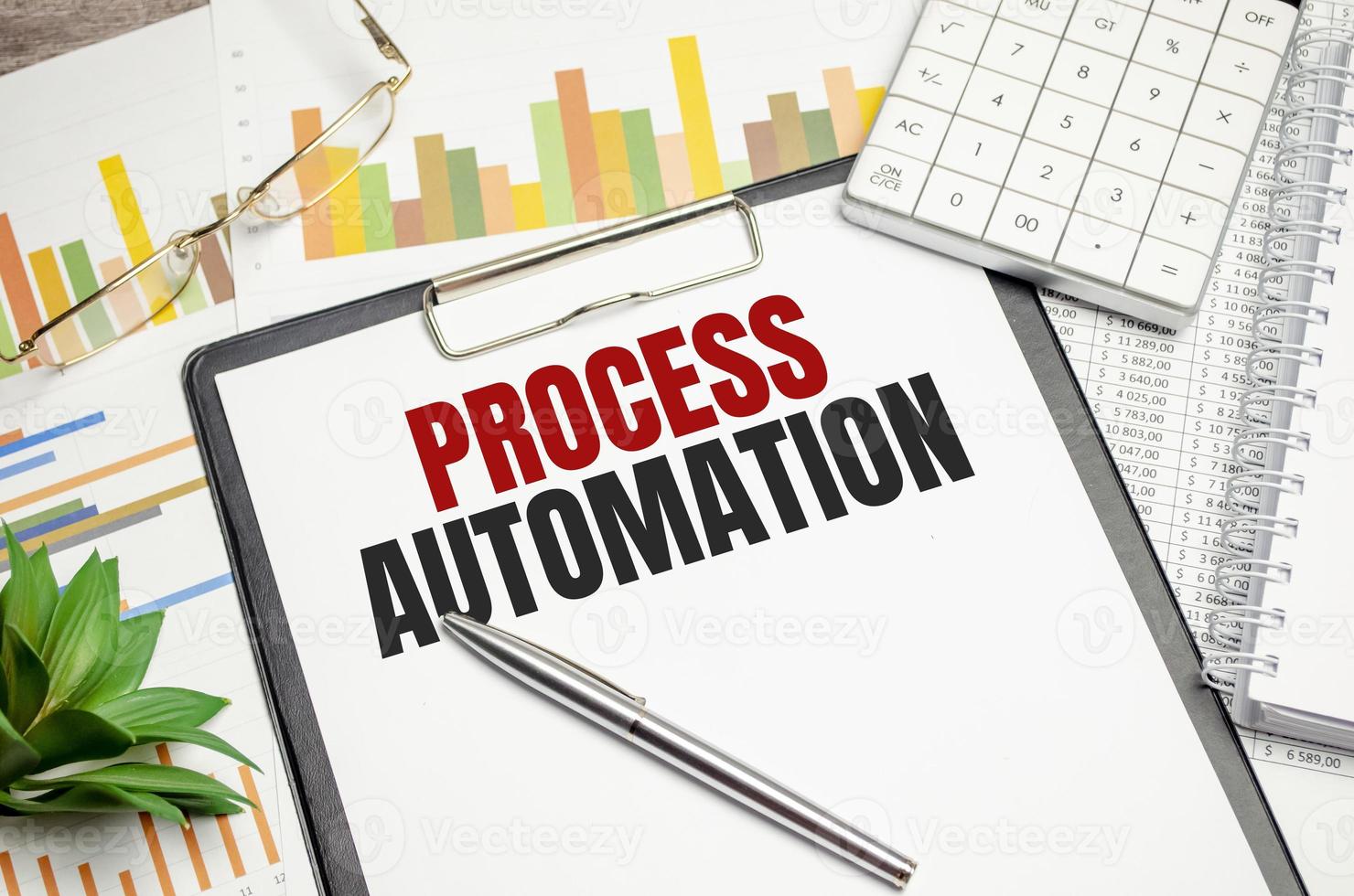 PROCESS AUTOMATION text on file folder and charts on wooden background photo