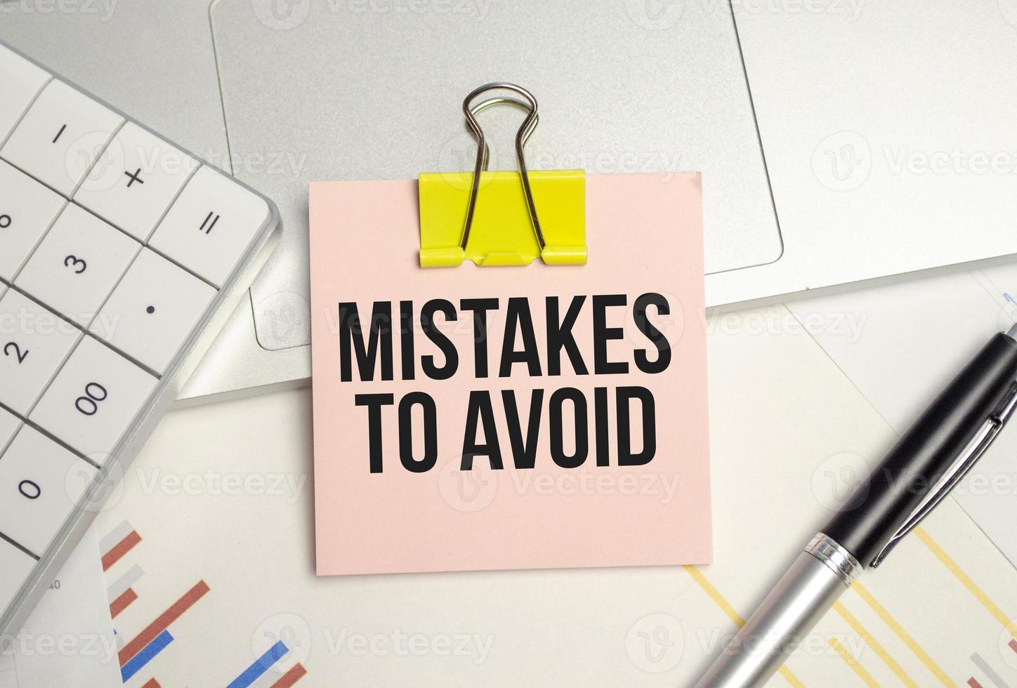 Business concept. Text MISTAKES TO AVOID on notepad and pen photo