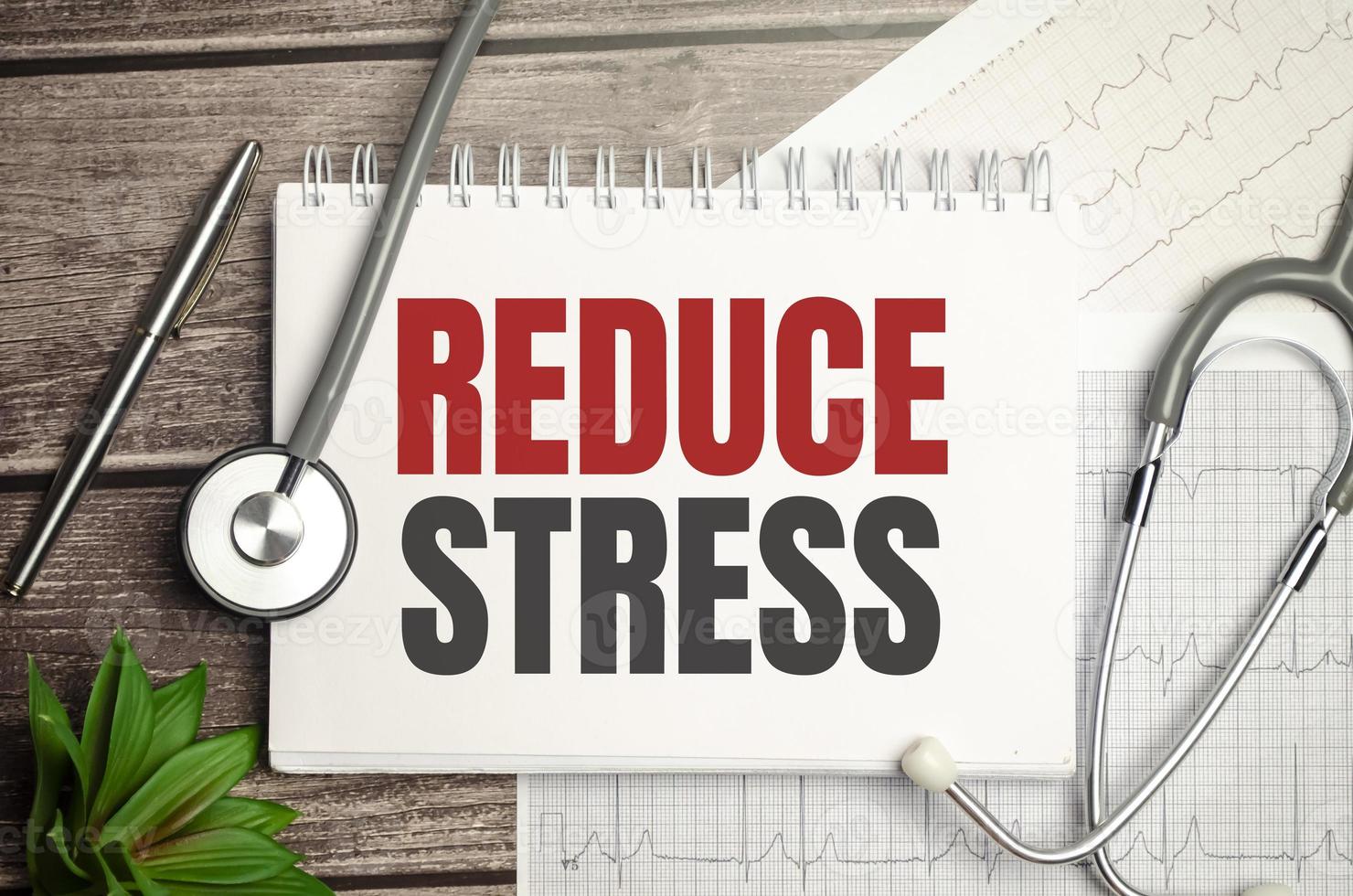 Text Reduce stress on a white background with stethoscope photo