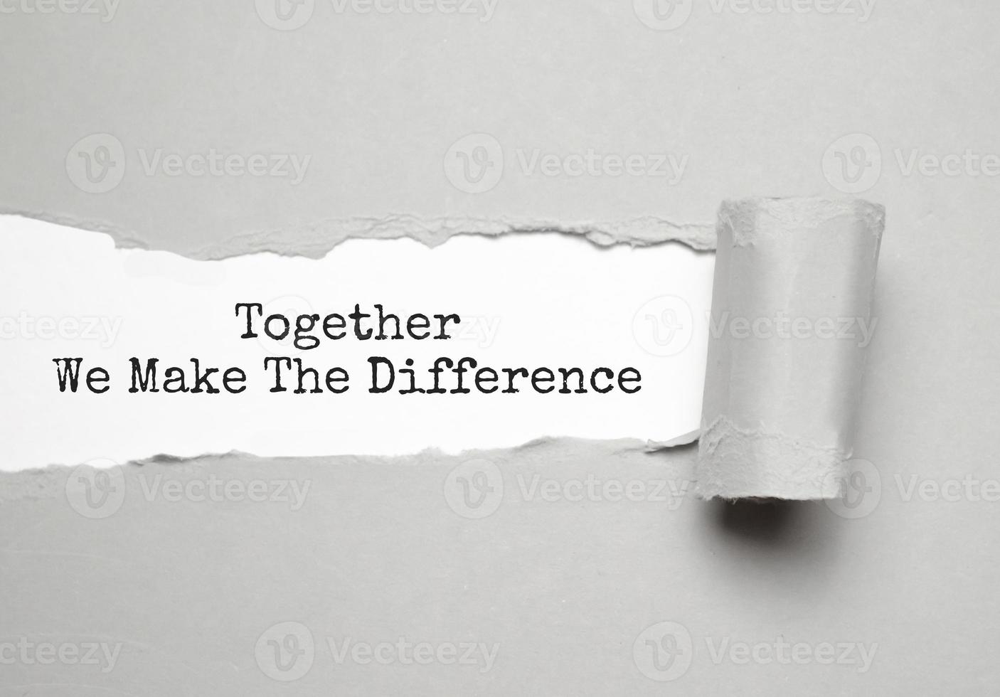 The word TOGETHER WE MAKE THE DIFFERENCE appearing behind torn brown paper. photo