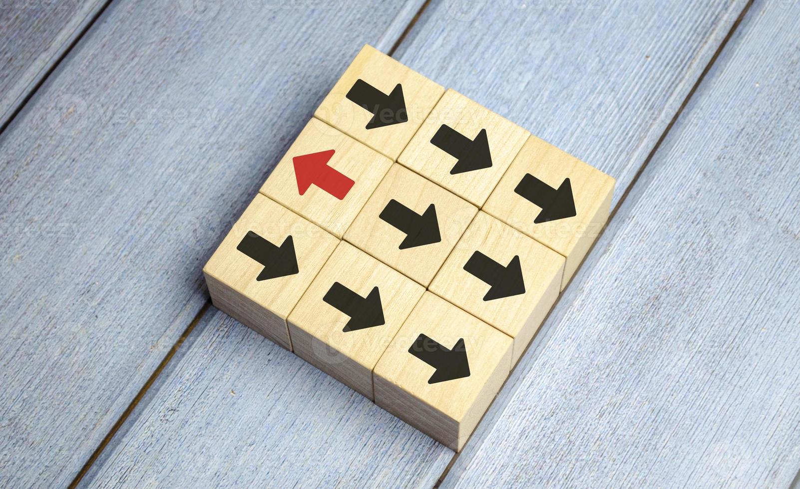 Leadership concept, Red wooden block with arrow icon on blue background. photo