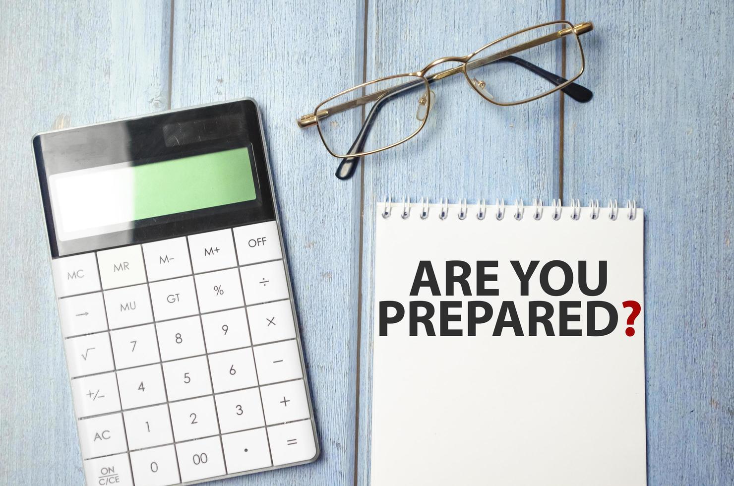 Are You Prepared Question text on notepad and glasses, calculator on wooden background photo