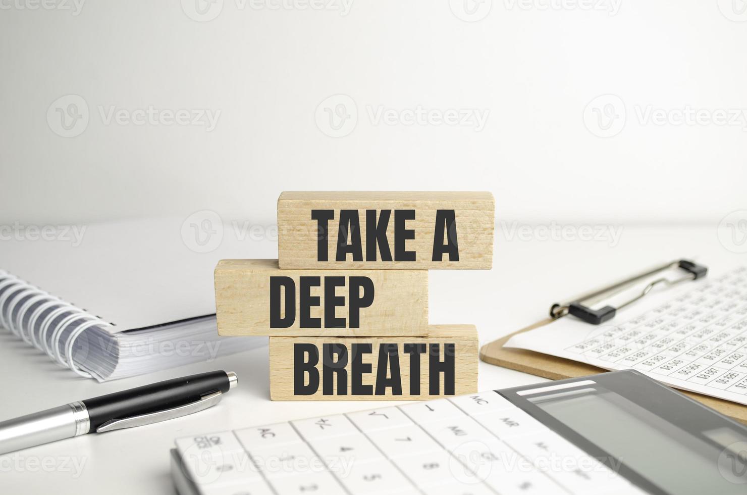 On a light background, wooden cubes and a wooden block with the text Take a deep breath. View from above photo