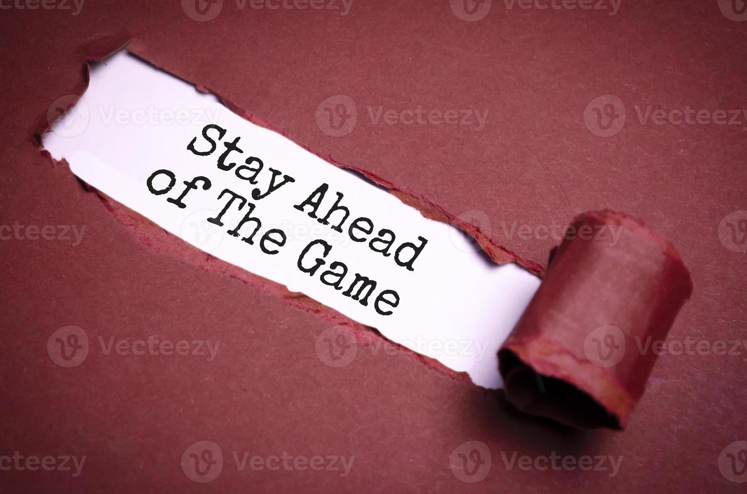 The text Stay Ahead of The Game appearing behind torn brown paper photo